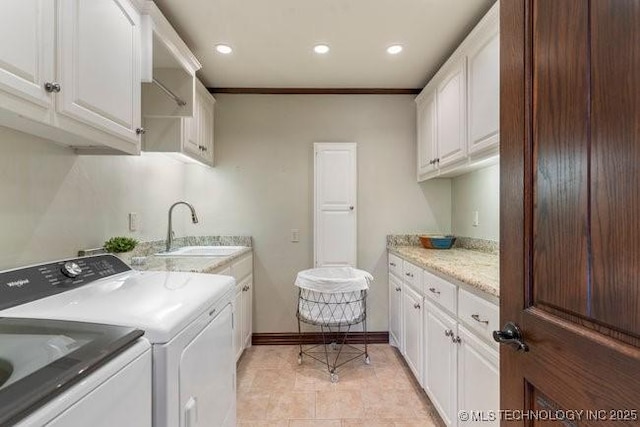 laundry room with washer and dryer, sink, crown molding, and cabinets