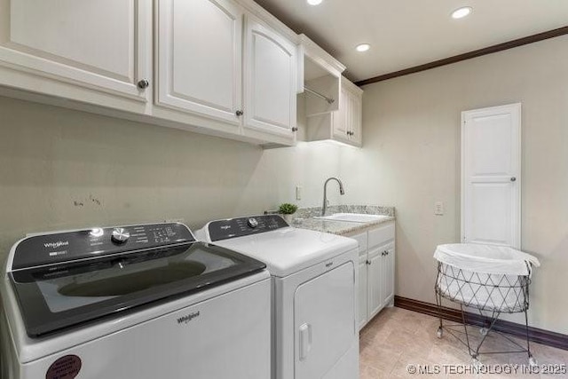 washroom with cabinets, independent washer and dryer, ornamental molding, and sink