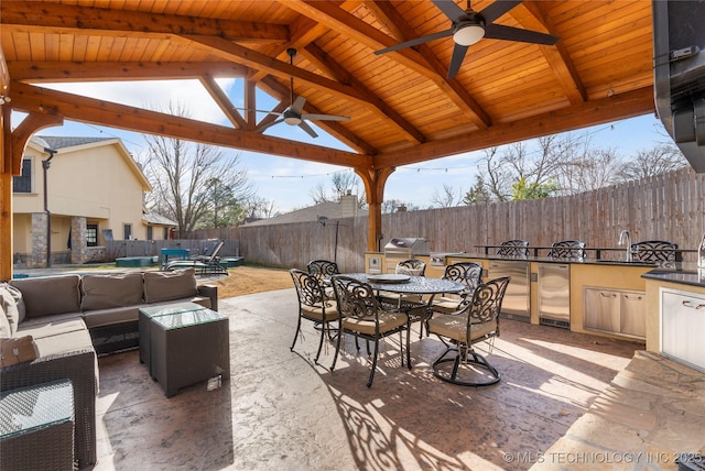 view of patio / terrace with an outdoor kitchen, sink, a gazebo, ceiling fan, and an outdoor living space