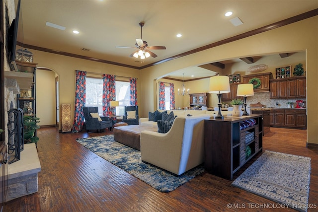 living room with dark hardwood / wood-style flooring, ceiling fan with notable chandelier, and ornamental molding