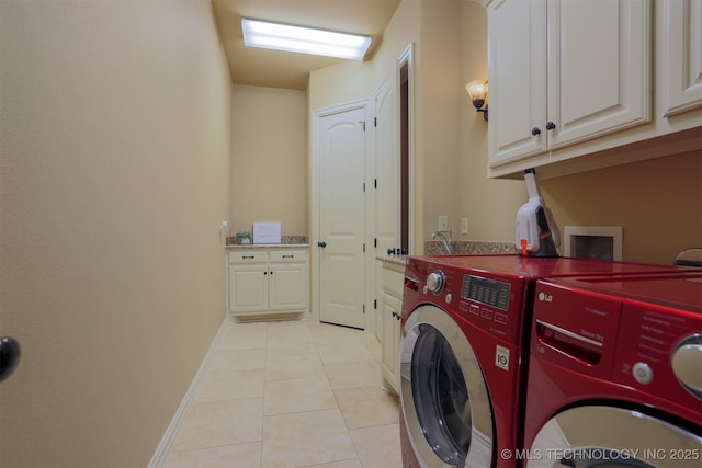 laundry room with light tile patterned floors, washing machine and dryer, and cabinets