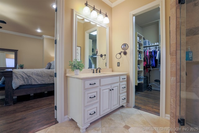 bathroom with crown molding, vanity, an enclosed shower, and tile patterned flooring