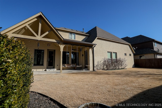 rear view of property with ceiling fan and a patio area