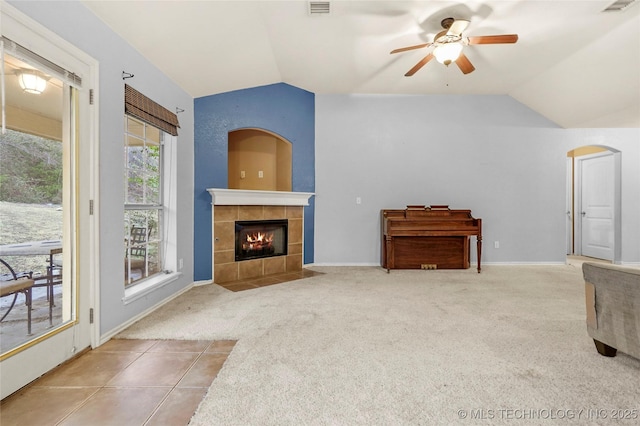 carpeted living room with lofted ceiling, a tiled fireplace, and ceiling fan