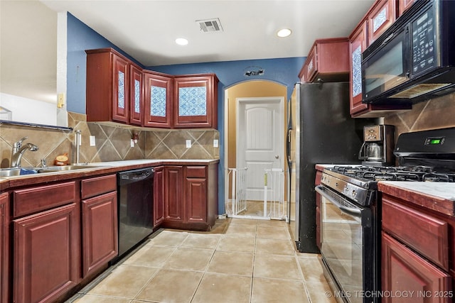 kitchen with tasteful backsplash, sink, light tile patterned floors, and black appliances