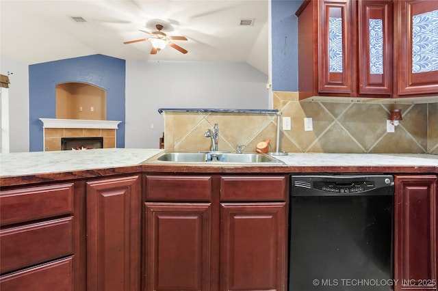 kitchen featuring lofted ceiling, black dishwasher, sink, and backsplash