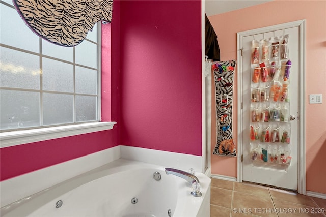 bathroom with a tub to relax in and tile patterned flooring