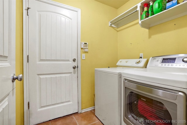 laundry room with washing machine and dryer and light tile patterned floors