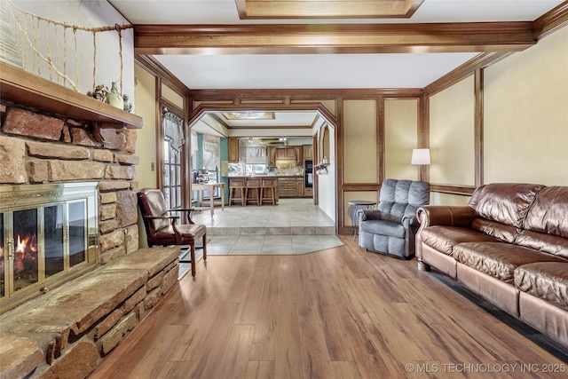 living room with ornamental molding, a fireplace, and light hardwood / wood-style flooring