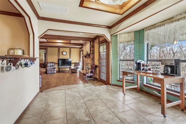 interior space with light tile patterned floors and ornamental molding