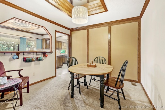 carpeted dining area featuring crown molding and a healthy amount of sunlight