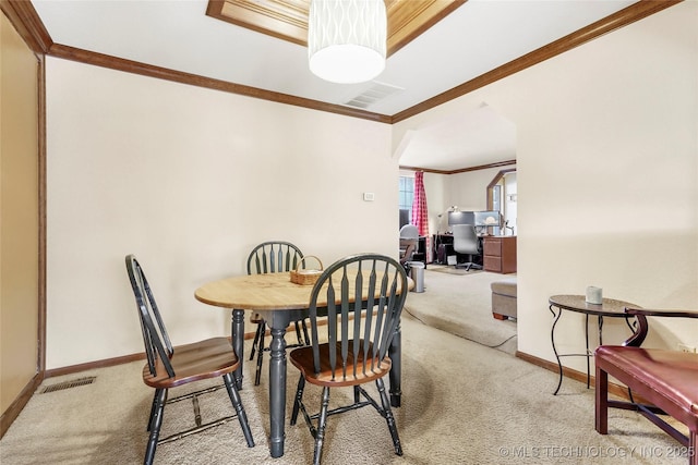 dining space with light colored carpet and ornamental molding