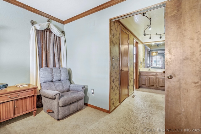 sitting room featuring crown molding, rail lighting, sink, and light carpet