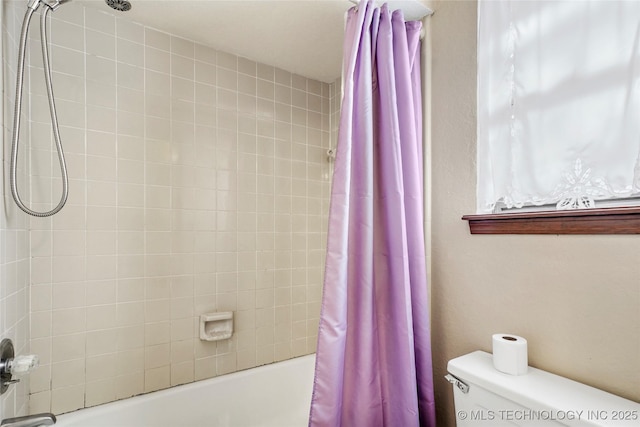 bathroom featuring shower / tub combo with curtain and toilet