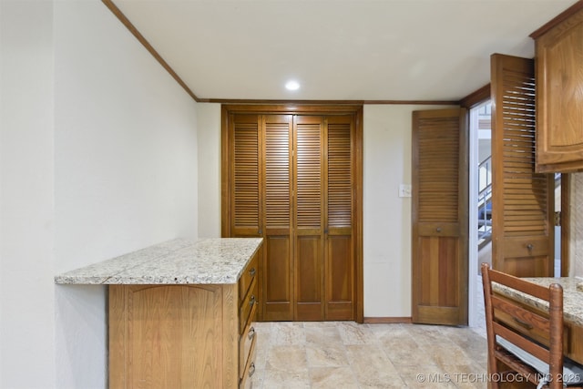 kitchen featuring light stone counters and ornamental molding