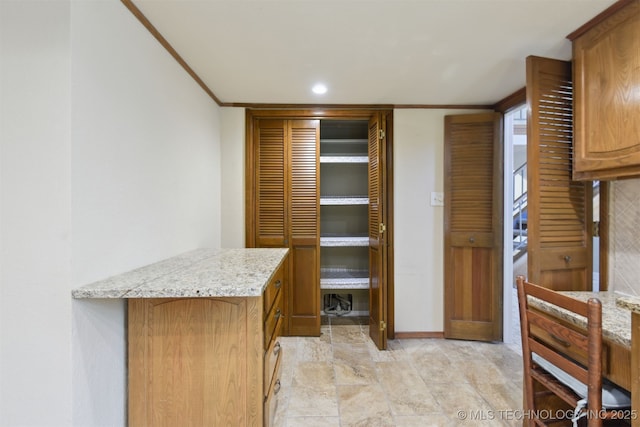 interior space featuring light stone counters and ornamental molding