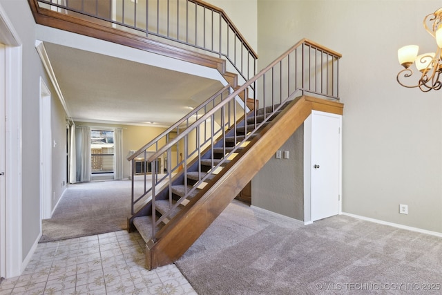 stairs with crown molding, a chandelier, carpet floors, and a high ceiling