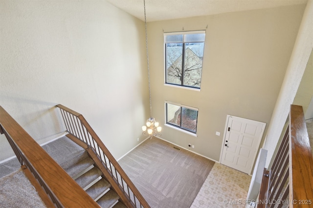 entrance foyer featuring a towering ceiling and a chandelier