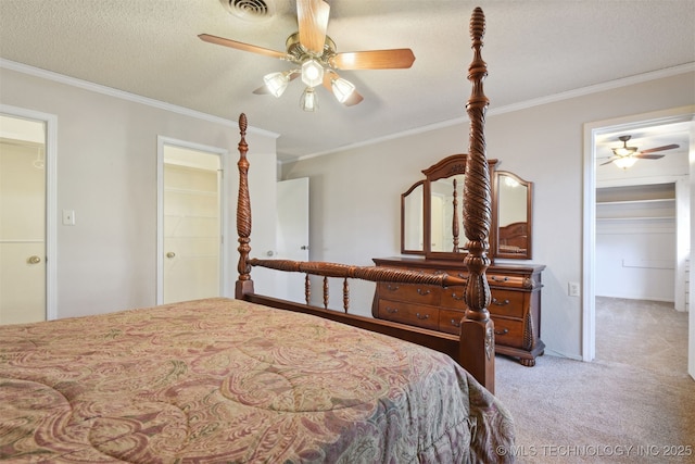 bedroom with ceiling fan, ornamental molding, carpet, and a textured ceiling