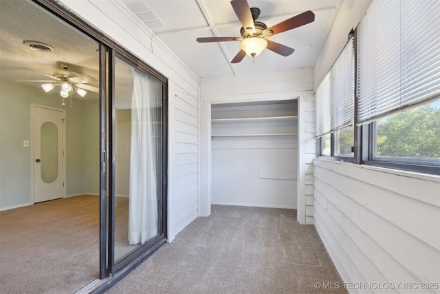 interior space with carpet floors and ceiling fan