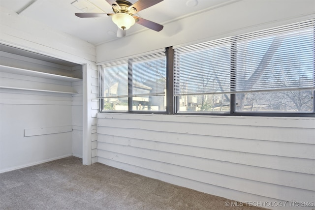 unfurnished bedroom with carpet floors, ceiling fan, and a closet