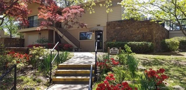 view of front of home featuring an attached garage and stairs