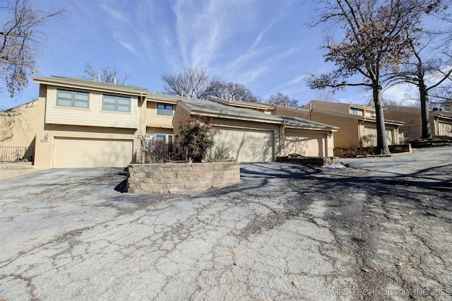 view of front of property with a garage, driveway, and stucco siding