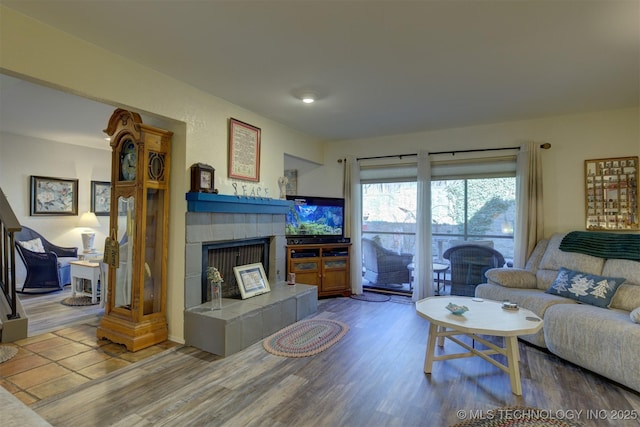 living area with a tiled fireplace and wood finished floors