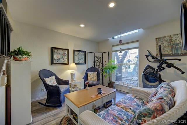 living room featuring baseboards, wood finished floors, and recessed lighting