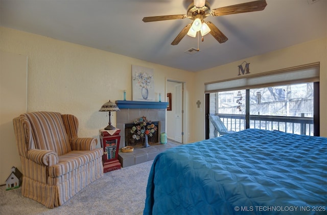 carpeted bedroom featuring access to exterior, ceiling fan, a fireplace, and visible vents