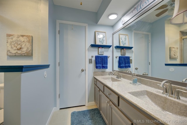 bathroom with double vanity, tile patterned flooring, a sink, and a ceiling fan