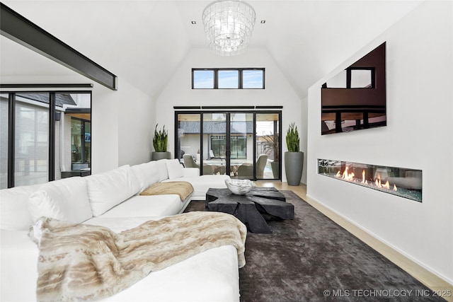 living room featuring high vaulted ceiling and a chandelier