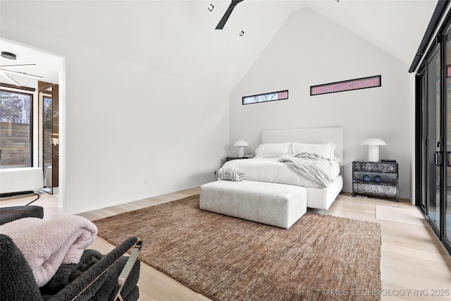 bedroom featuring ceiling fan, high vaulted ceiling, and light hardwood / wood-style floors