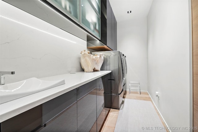 laundry area featuring washer and dryer, sink, and cabinets