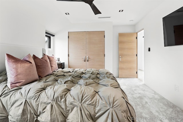 bedroom with light carpet, a closet, and ceiling fan