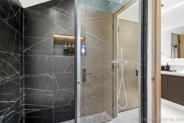 bathroom with vanity and tiled shower