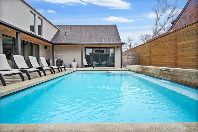 view of swimming pool with pool water feature and a patio area