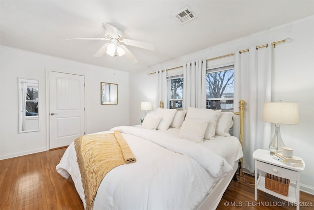 bedroom with ornamental molding, dark hardwood / wood-style floors, and ceiling fan