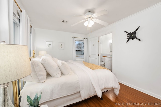 bedroom featuring ceiling fan, ensuite bath, and hardwood / wood-style floors