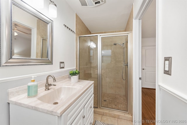 bathroom with an enclosed shower, vanity, and tile patterned floors