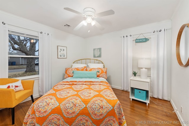 bedroom with crown molding, ceiling fan, and wood-type flooring