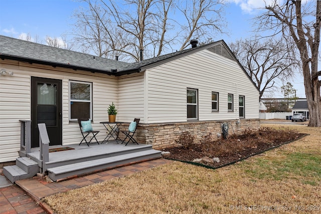 back of property with a lawn and a deck