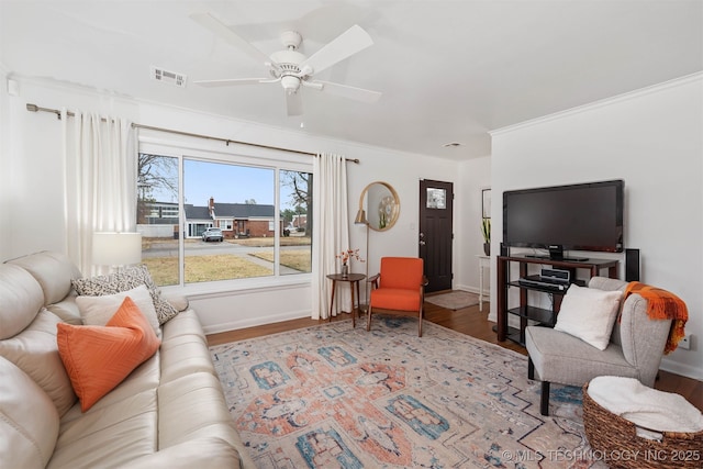 living room with crown molding, light hardwood / wood-style flooring, and ceiling fan