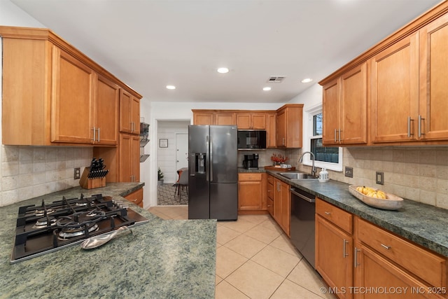 kitchen with sink, decorative backsplash, light tile patterned flooring, and appliances with stainless steel finishes