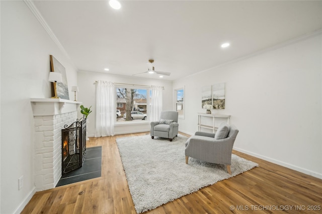 unfurnished living room featuring hardwood / wood-style flooring, ceiling fan, ornamental molding, and a brick fireplace