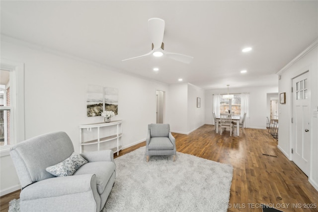 sitting room with hardwood / wood-style flooring, crown molding, and ceiling fan