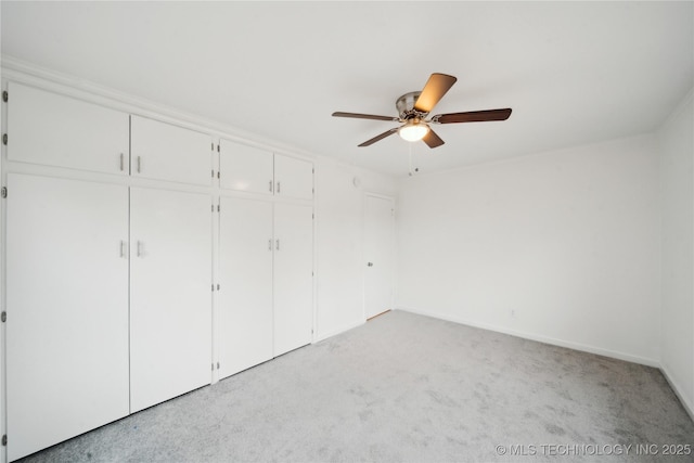 unfurnished bedroom featuring light colored carpet, ceiling fan, and a closet