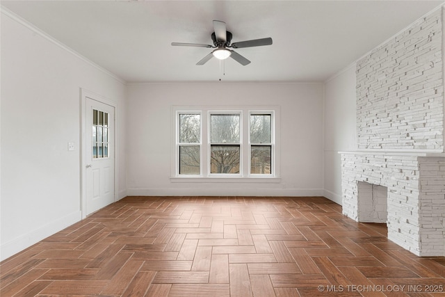 unfurnished living room with crown molding, ceiling fan, dark parquet flooring, and a stone fireplace