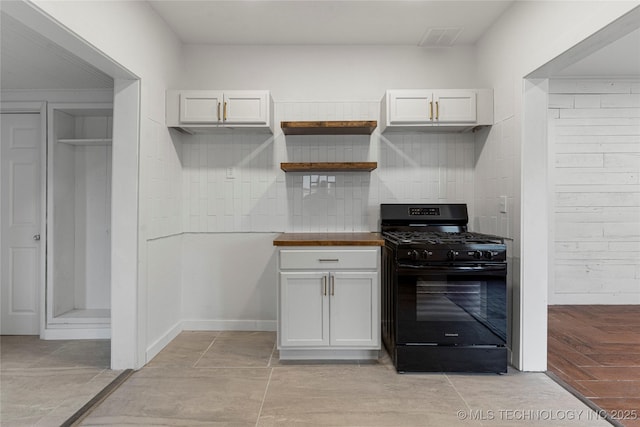 kitchen with tasteful backsplash, black gas stove, and white cabinets