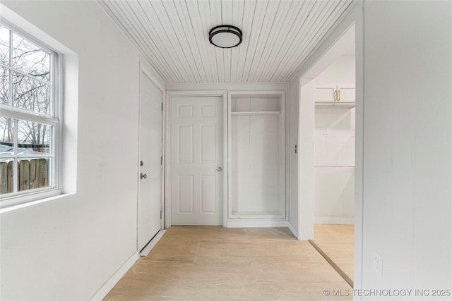 hall with wood ceiling and light hardwood / wood-style floors